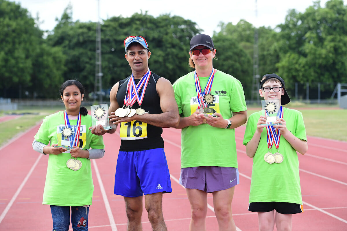 people posing with medals after athletics event