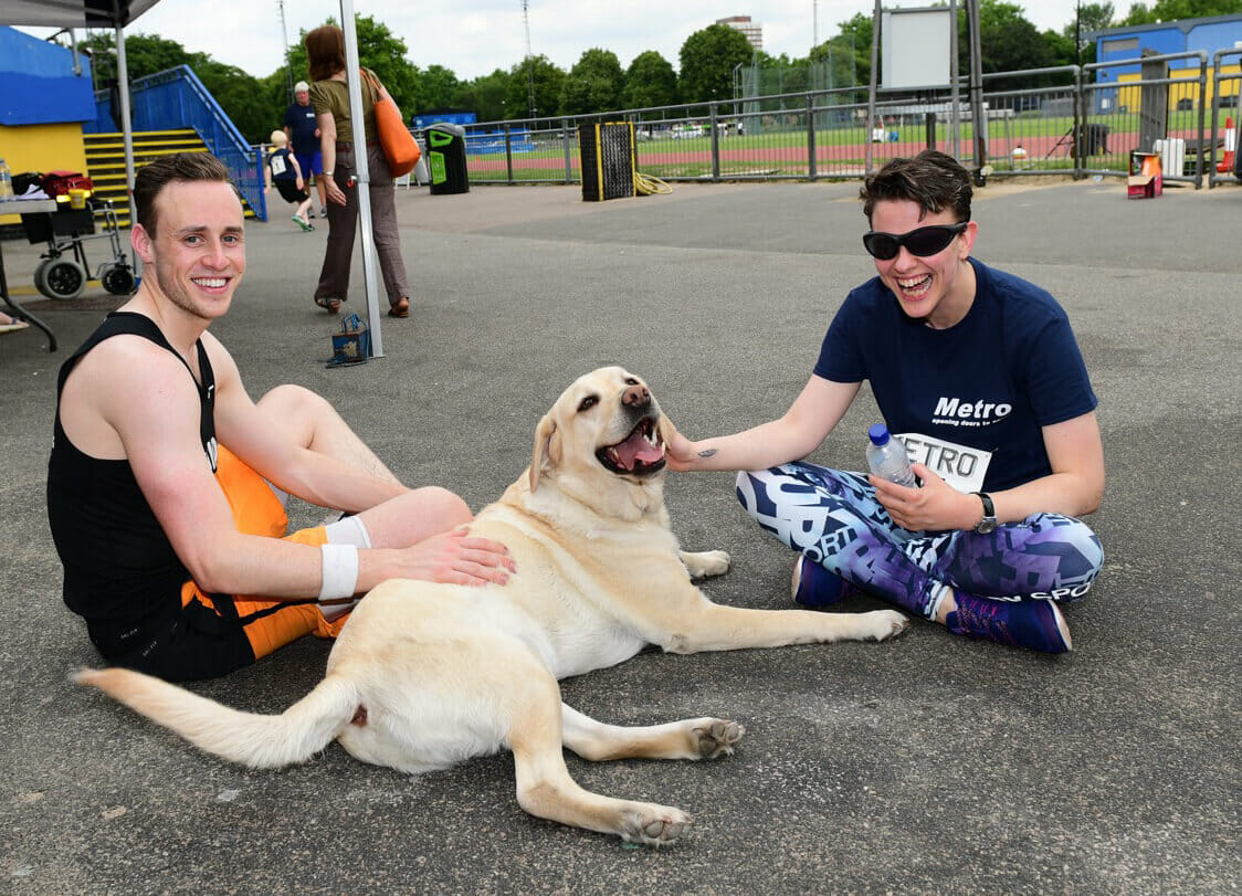 tow men cuddling with a dog